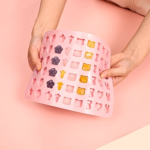 Flexible pink silicone fruit and animal candy mold shown being bent to test flexibility