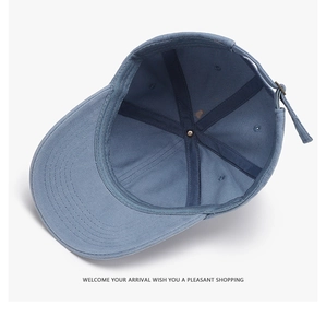 Detailed view of internal reinforced seams and adjustable metal strap on blue baseball cap