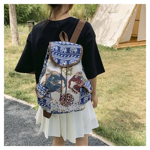 Ethnic canvas backpack with elephant embroidery shown from back on a female model outdoors