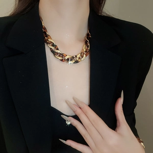 Detail of chunky gold and silver interlocking necklace with amber resin leopard print