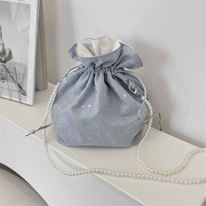 Detail of light blue drawstring bag with silver stars and white pearl chain strap