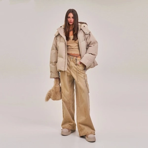 Detail of loose-fit beige down jacket with warm hood and high-density waterproof fabric
