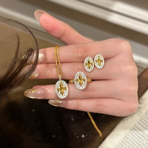 Detail showing vintage 18k gold plated jewelry set with iris flower motif and zircons