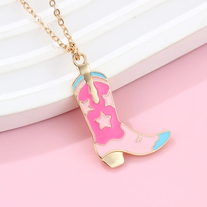 Dettaglio del ciondolo a stivale da cowboy dorato con smalto rosa e blu e decoro a stelle