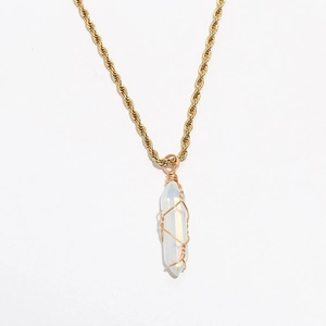 Macro view of crystal prism pendant with gold wire wrapping on bohemian rope chain