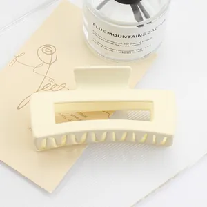 Close-up of large cream matte rectangle hair claw clip with a hollow design