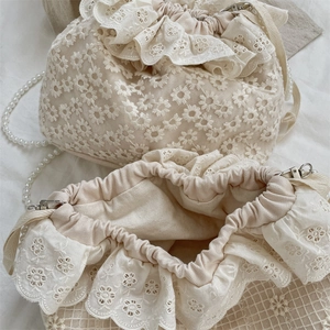 Nahaufnahme der Spitzen-Beuteltasche mit Kordelzug, Perlenkette und floralen Stickereien