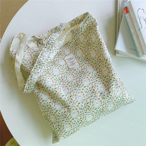 Detail of floral tote bag with poodle print featuring a woven label on natural cotton fabric