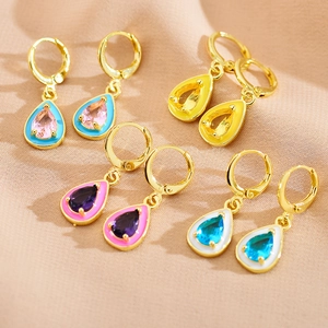 Macro shot of colorful enamel water drop earrings with faceted zircon on beige fabric