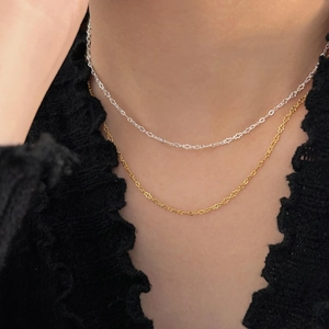 Detail of silver and gold minimalist star-shaped link necklaces on a model
