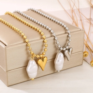 Detail view of gold and silver beaded necklaces with heart and pearl charms