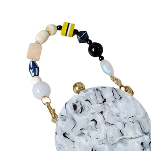 Chic acrylic marble handbag featuring unique colorful beaded handle and gold hardware
