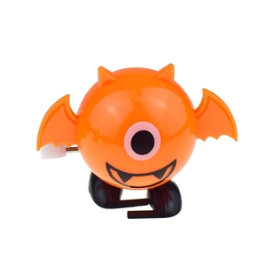 Detail view of orange wind-up bat toy with black wings and white rotating mechanical key
