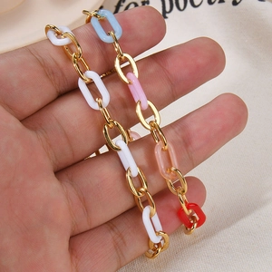 Close-up of colorful acrylic resin rings with gold stainless steel chain bracelet links