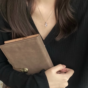 Detail shot of a minimalist silver chain necklace with a mini crystal lock pendant