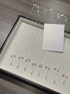 Detailed display of ten S925 silver necklaces with blue water drop pendants on a tray
