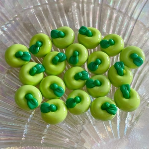 Macro di piccoli ciondoli a forma di mela verde in resina per gioielli e accessori