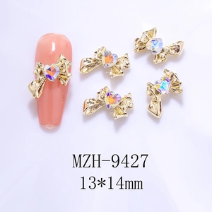 Detail of 13x14mm golden alloy bow nail charm with iridescent heart rhinestone inlay