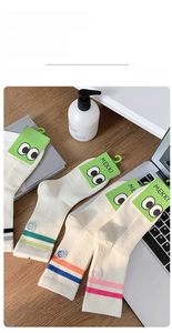 Detail of colorful striped cotton socks with embroidered smile faces on wooden background