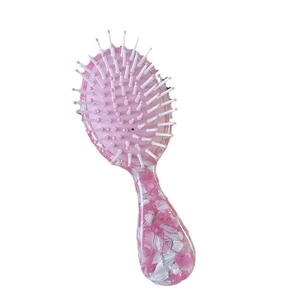 Cute pink and white marble pattern acetate hairbrush with massage cushion on white background