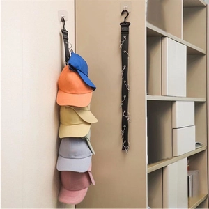 Wall-mounted hat rack with black nylon strap and metal clips for baseball cap storage