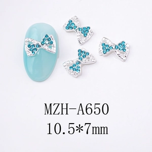 Détail de bijoux d'ongles nœuds argentés avec strass bleu turquoise mesurant 10,5x7mm