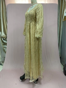 Detail eines Pailletten-Abendkleides in Champagnergold mit V-Ausschnitt und Stickereien