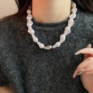 Gros plan d'un mannequin portant un collier en perles baroques avec fermoir argenté