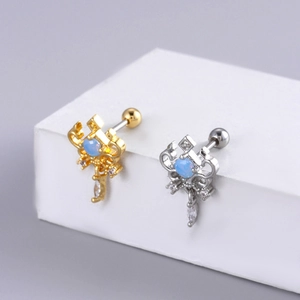 Détails de boucles d'oreilles piercing or et argent avec pierres bleues et gouttes