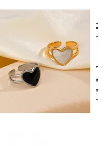 Detailed close-up of 18K gold and silver open heart rings on a soft silk surface