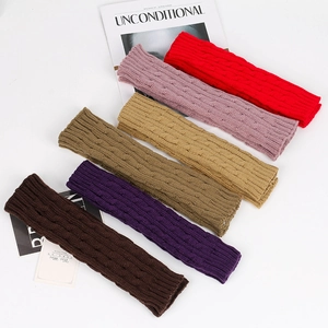 Flat lay of cable knit arm warmers in various colors including red, pink, and beige
