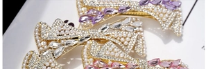 Detail of elegant bow hair clips with pearls and crystals in purple, pink and white