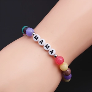 Detail of beaded bracelet with MAMA letter charms and colorful beads on a model arm
