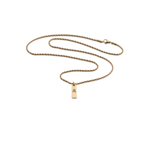 Close-up of golden alphabet necklace with sparkling zircon letter A on rectangular pendant