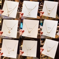Detail of assorted gold layered necklaces with butterfly, heart, and pearl charms on cards