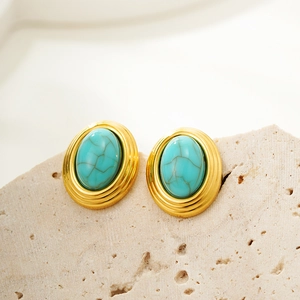 Macro detail of vintage oval earrings with turquoise stone and golden spiral texture