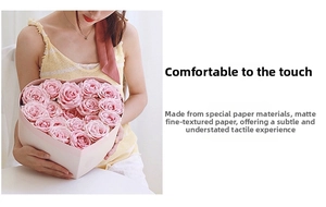 Macro shot of pink roses in a matte specialty paper heart-shaped gift box packaging