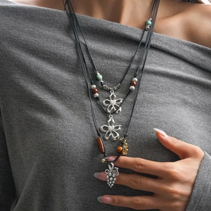 Détail du collier bohème multi-rangs avec breloque raisin en céramique et fleur argentée