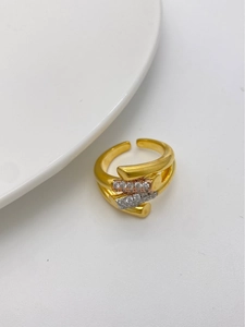 Macro detail of gold-plated cross ring featuring two rows of pavé micro-set cubic zirconia