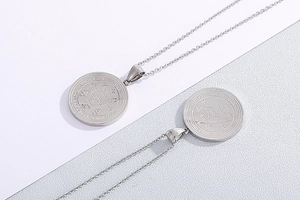 Macro detail of silver stainless steel pendant featuring engraved mystical SABAOTH symbols