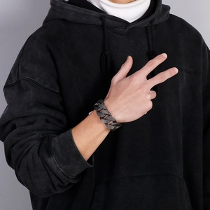 Men's vintage grey stainless steel Cuban link bracelet worn by a model in street style