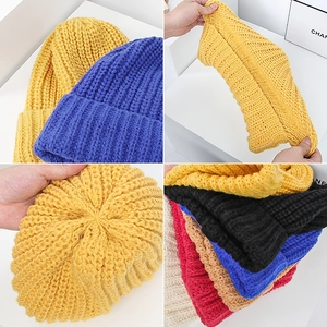 Detail showing various colors of elastic knitted beanie with thick yarn texture and cuff