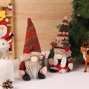 Detail of Christmas gnomes with knitted hats, pine needles, and holiday berry accents