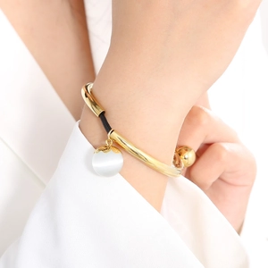Minimalist gold-plated bead bracelet with white cat-eye stone pendant on black rope