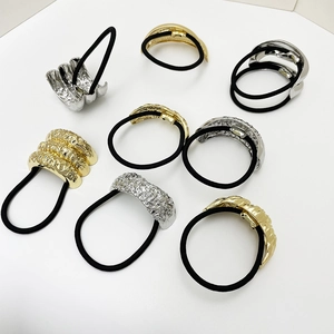 Detail of eight gold and silver metal hair cuffs with hammered texture on white background