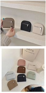 Flat lay of multiple semi-circular pebble leather mini purses in various pastel colors