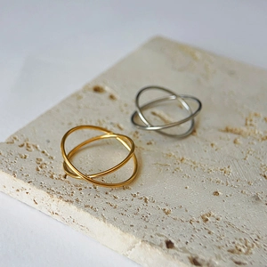 Close-up of interlocking gold and silver rings on a textured stone surface