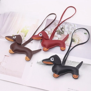 Three leather dachshund dog bag charms in brown, red, and black with long lanyards