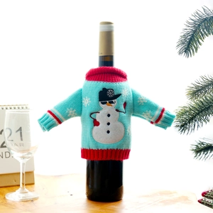 Knitted light blue Christmas wine bottle cover with snowman pattern and red trim