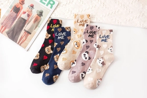 Detail view of five pairs of cotton socks featuring animal patterns and Love Me embroidery